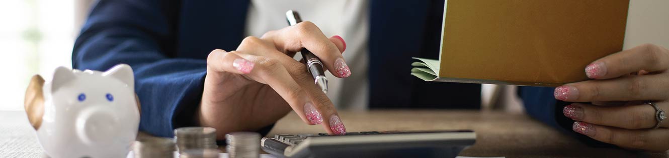 Person using a calculator to balance a checkbook.